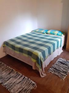 a bed in a room with a checkered blanket at Pez Espada in Punta del Este