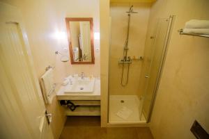 a bathroom with a shower, sink, and toilet at Hotel Pacsirta in Sovata