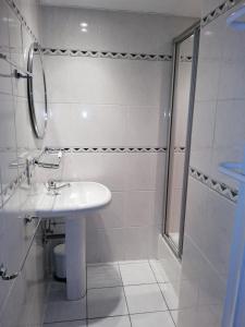 uma casa de banho branca com um lavatório e um chuveiro em DURBUY-COSY Appartement 2 em Durbuy