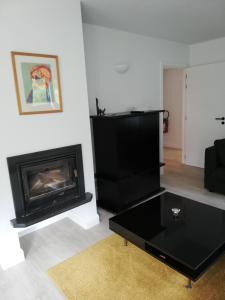 a living room with a fireplace and a black coffee table at DURBUY-COSY Appartement 2 in Durbuy