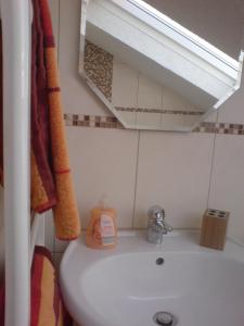 y baño con lavabo blanco y espejo. en Fewo-Nescht en Vaihingen an der Enz