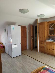a kitchen with a white refrigerator and wooden cabinets at Fewo-Nescht in Vaihingen an der Enz