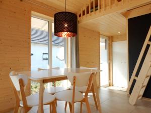 a dining room with a white table and chairs at Schwarzes Holzferienhaus mit Sauna in Zierow -- SONNENECK -- 500m zum Ostsee-Strand, 4 - 6 Personen in Zierow