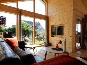 a living room with a couch and a table at Schwarzes Holzferienhaus mit Sauna in Zierow -- SONNENECK -- 500m zum Ostsee-Strand, 4 - 6 Personen in Zierow