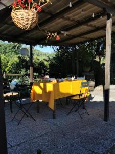 een gele tafel en stoelen onder een pergola bij Podere Ripabianca in Riparbella