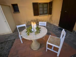 Ein Tisch mit zwei Kerzen und Stühlen auf einer Terrasse in der Unterkunft Podere Ripabianca in Riparbella