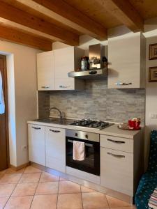 cocina con armarios blancos y fogones en Casa Prabellino en Caspoggio