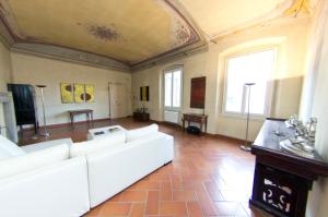 ein Wohnzimmer mit einem weißen Sofa und einer Decke in der Unterkunft TRAVIATA APPARTAMENTO STORICO - PALAZZO TOLOMEI in Florenz