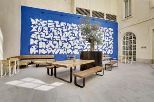 uma grande parede azul com mesas e bancos numa sala em The People - Marseille em Marselha