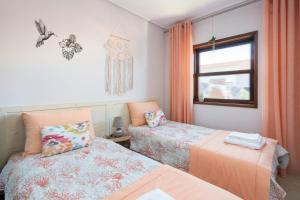 1 dormitorio con 2 camas y ventana en Beach Shell House, en Cortegaça