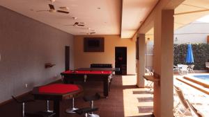 a pool table in a living room with a pool table at Pousada Kaluanã in Olímpia