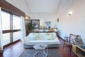 uma sala de estar com um sofá branco e uma mesa em Beach Shell House em Cortegaça