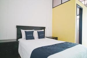a bedroom with a large bed with two pillows at Capital O Los Angeles, Chiapa de Corzo in Chiapa de Corzo
