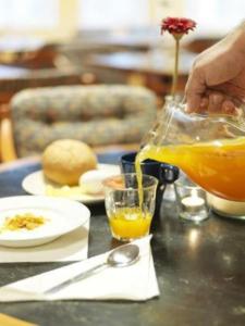 a person is pouring a glass of orange juice at Hotell Dialog in Stockholm