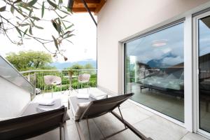 1 dormitorio y balcón con mesa y sillas. en Hotel Lisetta, en Tirolo