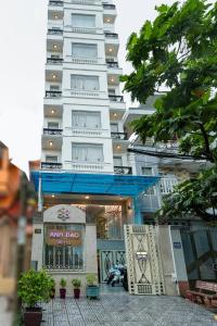 Un grand bâtiment blanc avec un panneau devant. dans l'établissement Anh Dao Hotel, à Hô-Chi-Minh-Ville