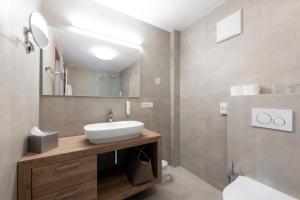 uma casa de banho com um lavatório e um espelho em Hotel Lisetta em Tirolo