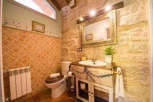 łazienka z umywalką, toaletą i lustrem w obiekcie Cas do Mestre Casa rural con Encanto w mieście Pontevedra