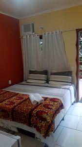 a bedroom with a large bed with a window at Pousada Serraninhos in Santa Leopoldina