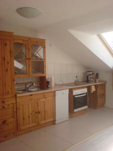 una cocina con armarios de madera y un aparato blanco en Fewo-Nescht en Vaihingen an der Enz