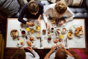 Eine Gruppe von Menschen, die an einem Tisch sitzen und Essen essen. in der Unterkunft Hotel Europe in Zürich