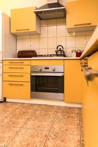 a kitchen with yellow cabinets and a stove at Marymont in Warsaw