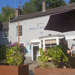 a woman sitting in front of a building at Gorgeview Cottage in Ironbridge