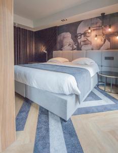 a bedroom with a large bed and a poster of a man at Ostend Hotel in Ostend