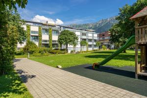 une aire de jeux avec toboggan en face d'un bâtiment dans l'établissement Hotel Artos Interlaken, à Interlaken