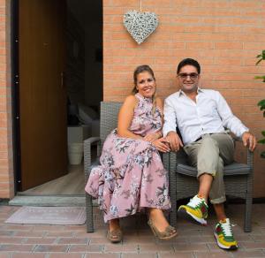 a man and a woman sitting on a bench at Alba Serena Camere in Alba