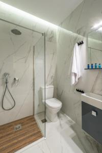 uma casa de banho com um chuveiro, um WC e um lavatório. em The Averof (Kalimarmaro) City Center Apartment em Atenas