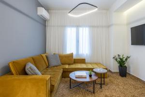 The Averof (Kalimarmaro) City Center Apartment في أثينا: غرفة معيشة مع أريكة وطاولة