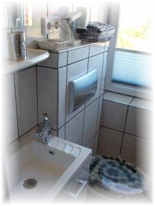 un piccolo bagno con lavandino e finestra di Pension Gästehaus Elfriede Baltrum a Baltrum