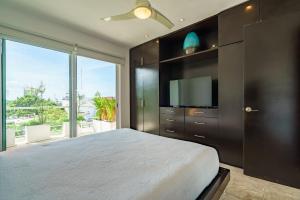 a bedroom with a large bed and a large window at Duplex w Rooftop Plunge Pool – Walk to Beach in Playa del Carmen +16 photos