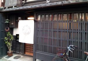 ein Fahrrad, das vor einem Gebäude mit einem Tor geparkt ist in der Unterkunft Kyoto Villa Chiyotsuru in Kyoto + 38 Fotos