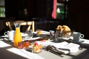 una mesa con un plato de comida y una botella de zumo en Hôtel Restaurant Le Moulin de Saint Verand en Saint-Vérand