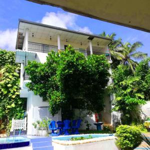 a white building with blue chairs in front of it at Elliot Nature Resort in Galle