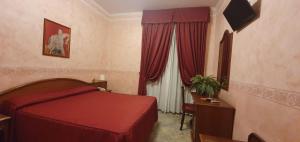 sypialnia z czerwonym łóżkiem i oknem w obiekcie Hotel Orazia w Rzymie