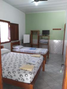 a room with two beds and a tv in it at Pousada Muralha in Pirenópolis