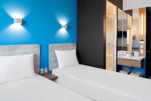 
a hotel room with two beds and two lamps at ibis budget Santiago Providencia in Santiago
