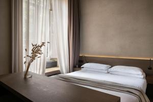 ローマにあるホテル デイ バルビエリのベッドと窓が備わるホテルルーム