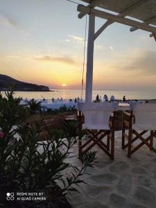 a table and chairs under an umbrella on the beach at Sunset Studios & Rooms in Antiparos