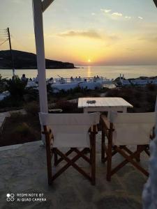 a table and two chairs on a patio with the sunset at Sunset Studios & Rooms in Antiparos