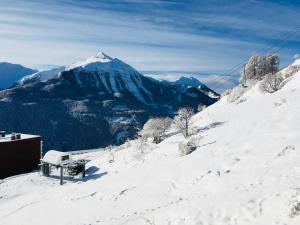 een met sneeuw bedekte berg met een bank erop bij Orcieres joli studio in Orcières