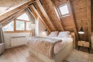 a bedroom with a large bed in a room with wooden ceilings at Mike by Totiaran in Naut Aran
