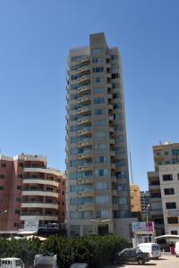 a tall building with cars parked in a parking lot at Code Housing - Fintas - family only in Kuwait