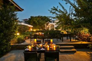 a patio with tables and chairs at night at The Fern Samali Resort in Dapoli
