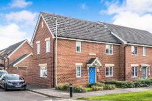 uma casa de tijolos vermelhos com uma porta azul em Lakeside-Dakota 3bed house 2bath parking M27 J5 Southampton Airport sleeps 6 em Eastleigh