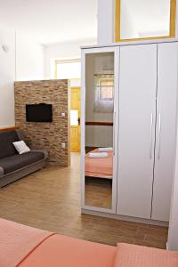 a living room with a large white cabinet and a couch at Studio Apartman Zara in Zadar