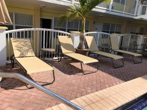 een groep stoelen en een palmboom op een patio bij Beach Place Hotel in Miami Beach